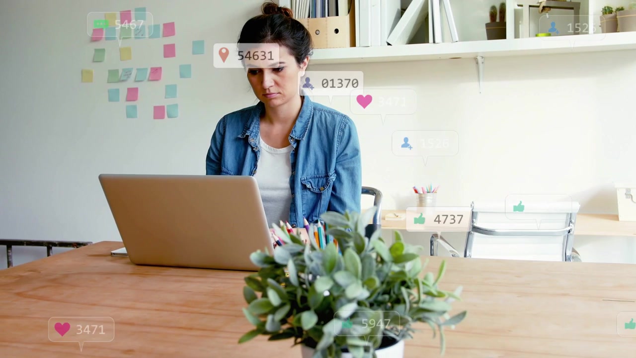 Woman typing at laptop, causing marketing alerts to fill desk, highlighting notes and shelves