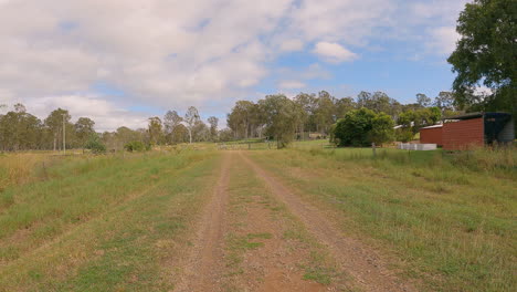 Sicht-Der-Wanderer,-Die-Durch-Den-Busch-Wandern,-Alte-Eisenbahnlinie,-Erhöhte-Kanten,-Kiesweg,-Alte-Schuppen-Und-Bäume-Entlang,-Brisbane-Valley-Rail-Trail,-Qld-4k