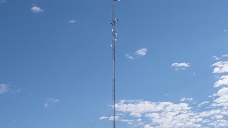 time lapse shot of 5g 6g transmission antenna tower against moving clouds and blue sky