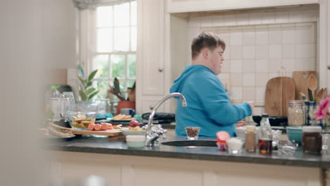 un adolescente feliz con síndrome de down bailando en la cocina divirtiéndose celebrando un baile divertido disfrutando del fin de semana en casa