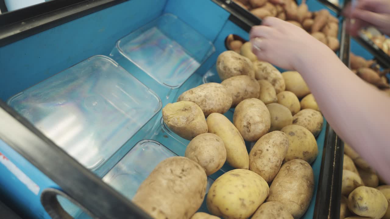 Filling of potatoes into food shelf at grocery store in Minnesota, USA.