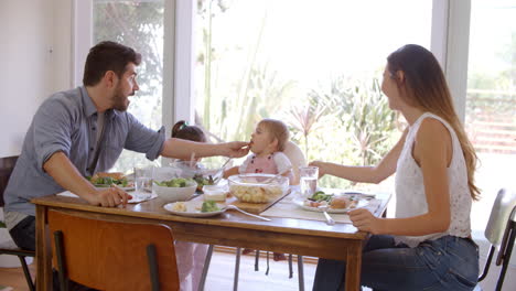 Familia-Disfrutando-De-La-Comida-En-Casa-Juntos-Rodada-En-Cámara-Lenta