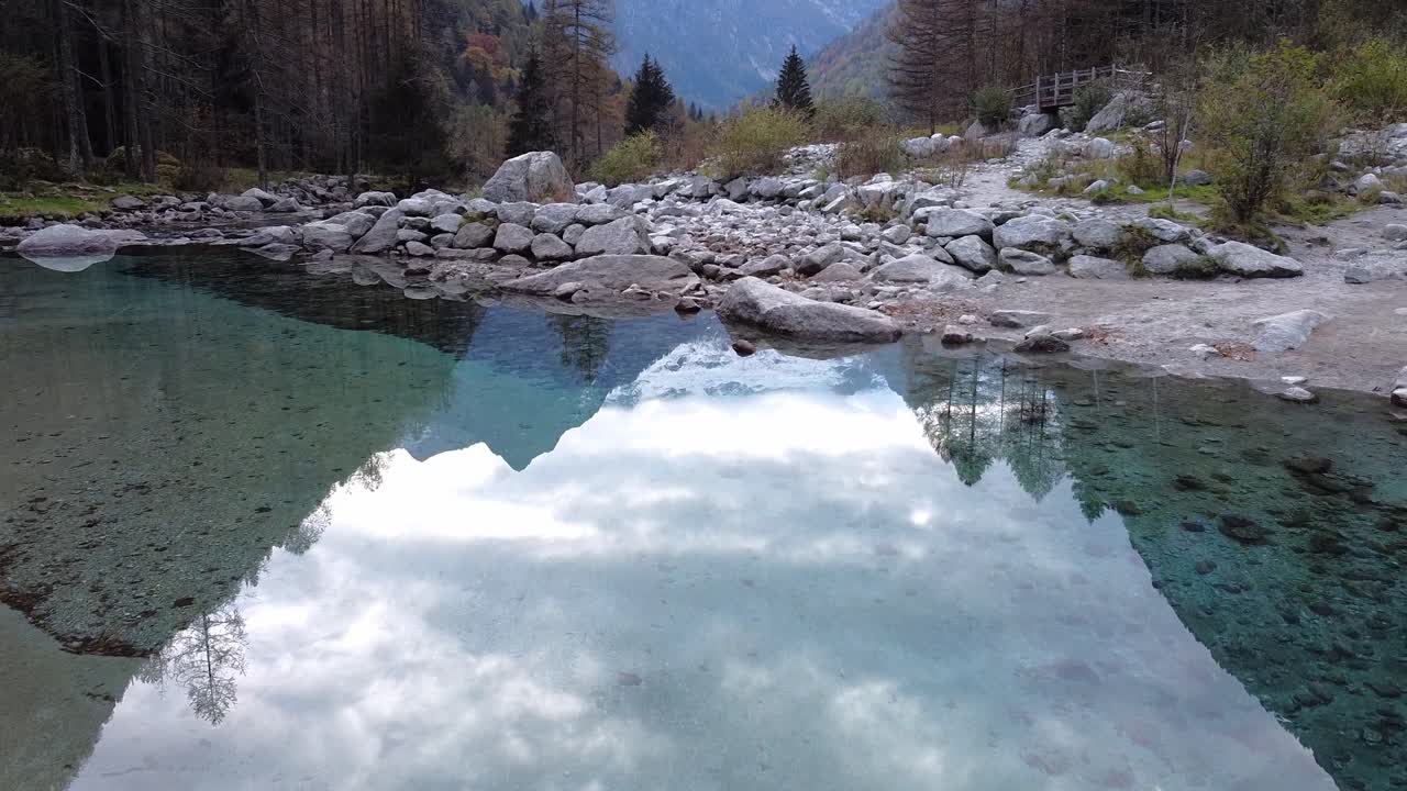 Drone on the forest in Val di Mello, on the river's reflections, Italy