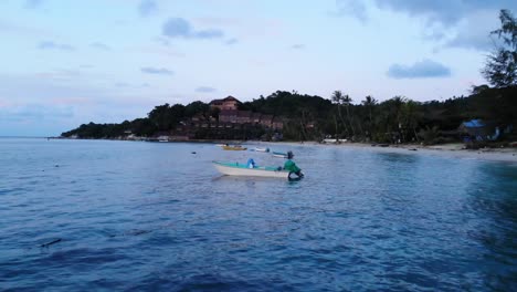 Boats-Sway-along-the-Beach-during-Sunset-Blue-Hour-in-Thailand,-Drone-Shot