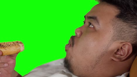 closeup of overweight man eating donuts