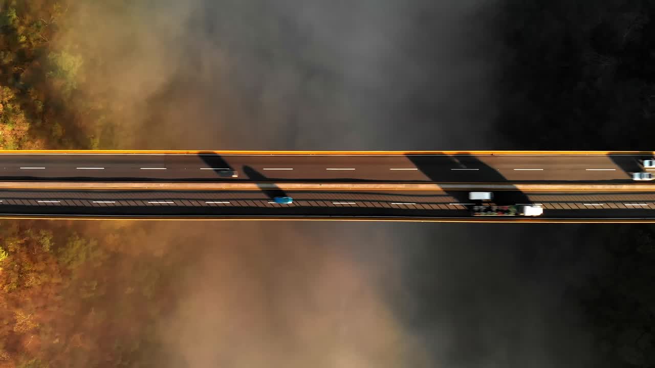 Aerial View of a Bridge with Cars Driving Through Fog