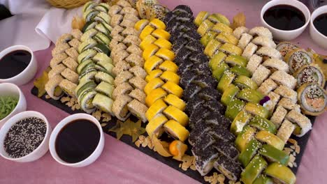 sushi, a table with a beautiful arrangement of rolls and soy sauce