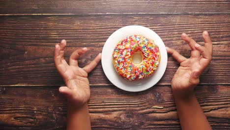 las manos del niño alcanzando una rosquilla colorida