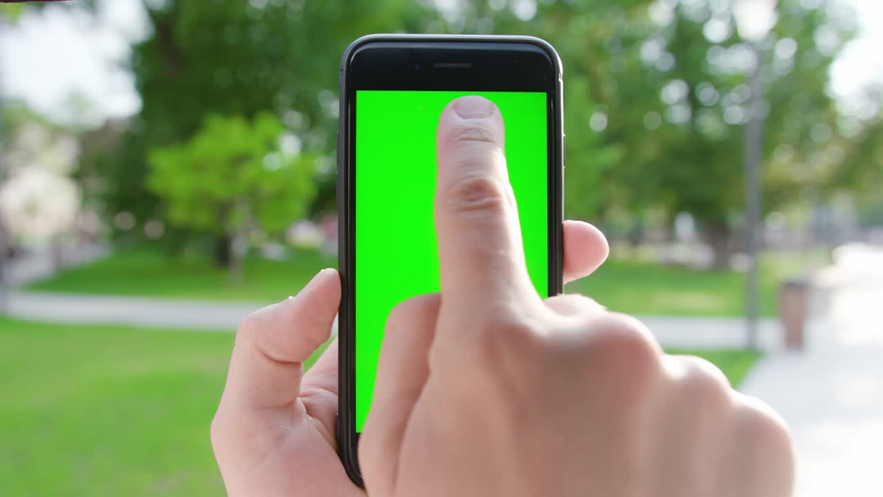 Una mano che tiene un telefono con schermo verde