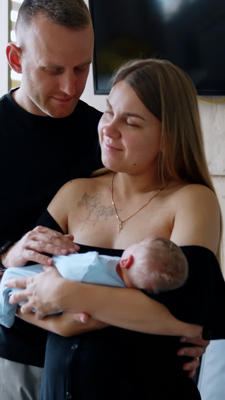 Happy Caucasian couple with a newborn in the hospital. Couple in the maternity ward after childbirth. Vertical video