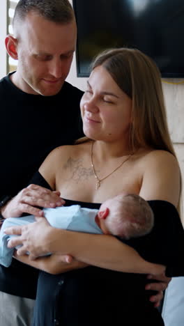 happy caucasian couple with a newborn in the hospital. couple in the maternity ward after childbirth. vertical video