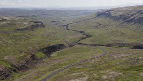 tilting-drone-video in island mit blick auf eine schöne grüne straße, die sich durch das üppige tal in der nähe von bifrost in nordisland schlängelt