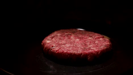 raw hamburger patty in a pan