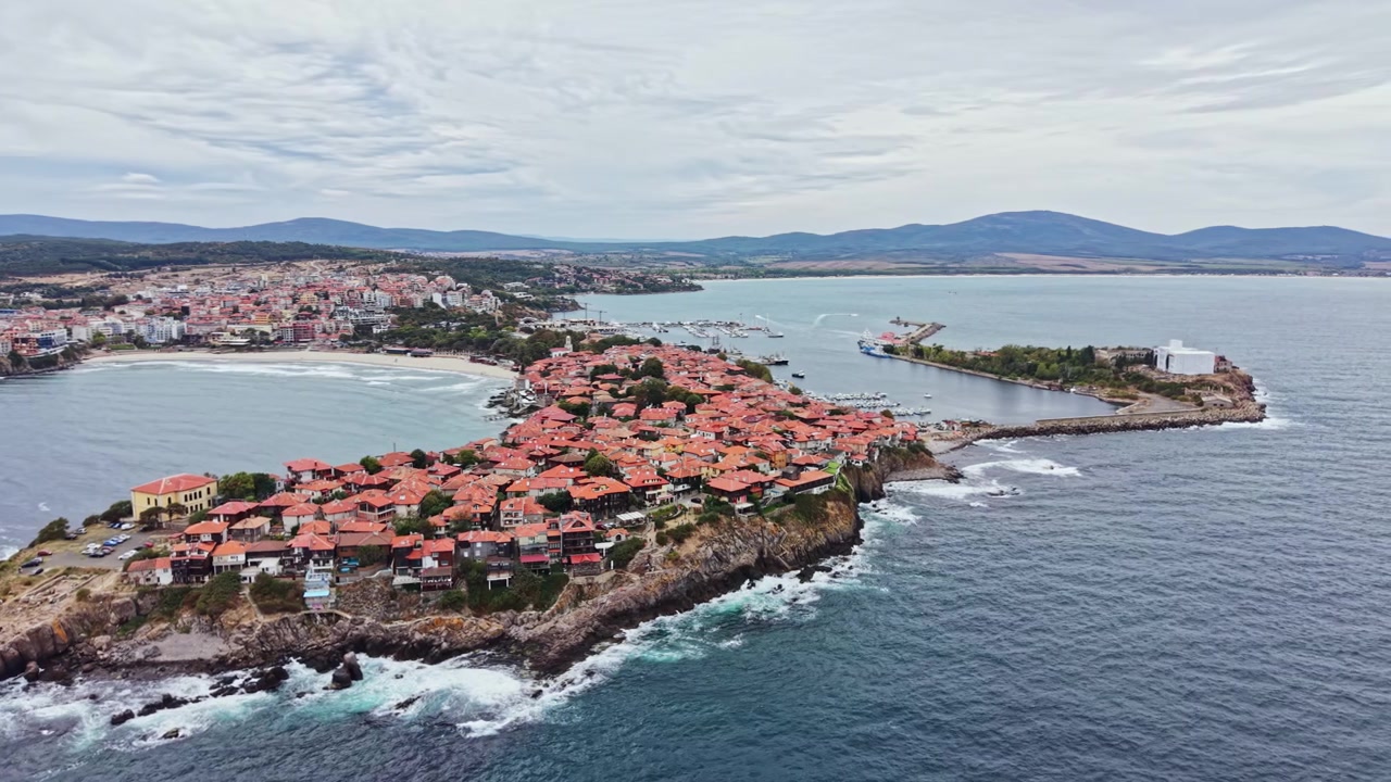 Vista costiera di una piccola città con tetti rossi circondata dall'acqua, situata sul bordo di una penisola vicino alla riva