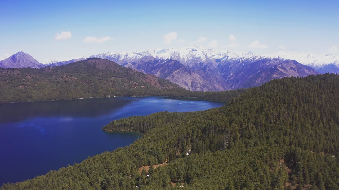 A calm aerial view of Rara Lake in Nepal shows its crystal-clear water surrounded by peaceful hills and Himalayan scenery, highlighting the beauty of this remote high-altitude destination
