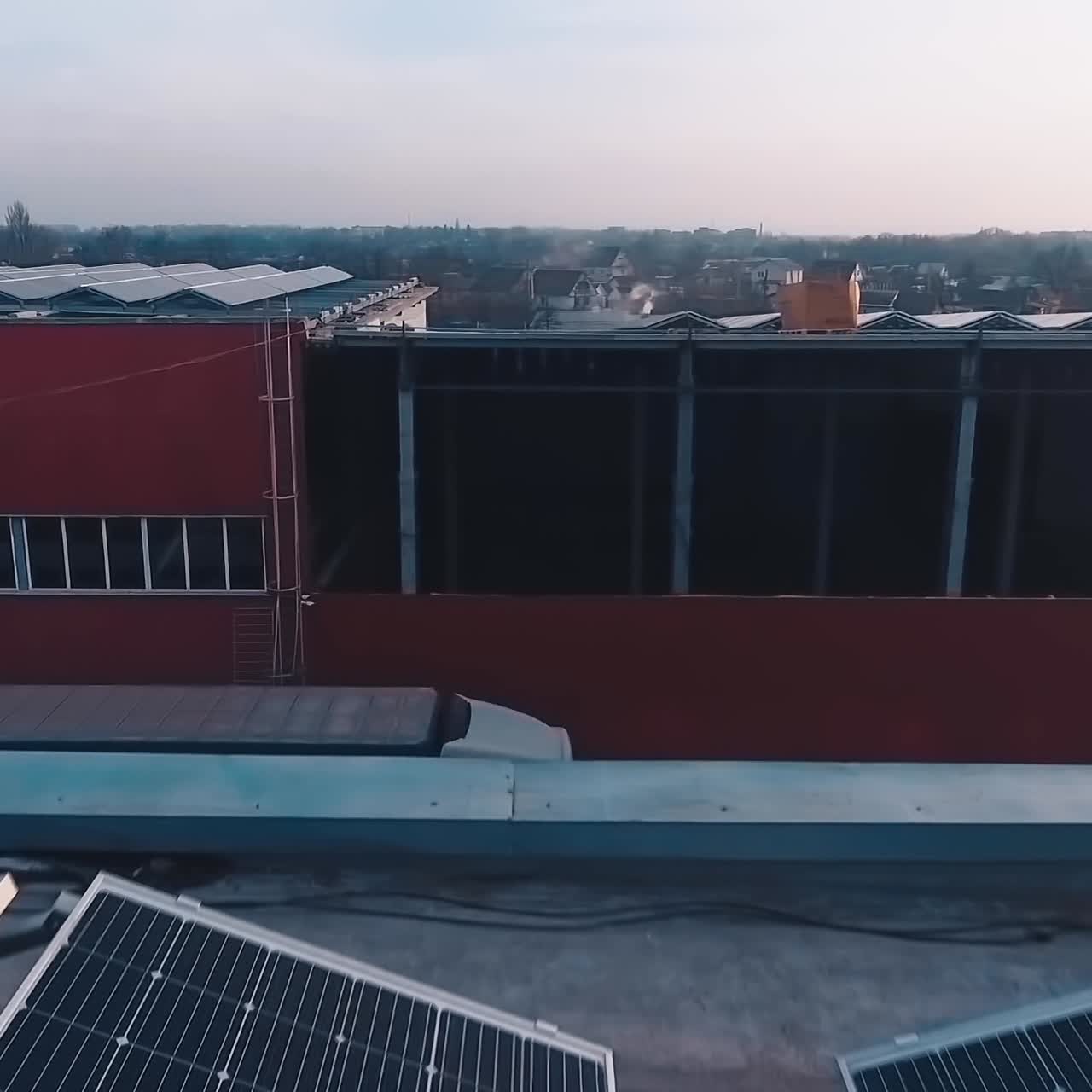 Solar panels farm on roof with setting sun. Drone flight over solar panels. Renewable green alternative energy concept. Aerial view.