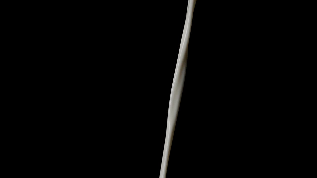 검은 배경 앞에서 우유가 쏟아지는 클로즈업 샷