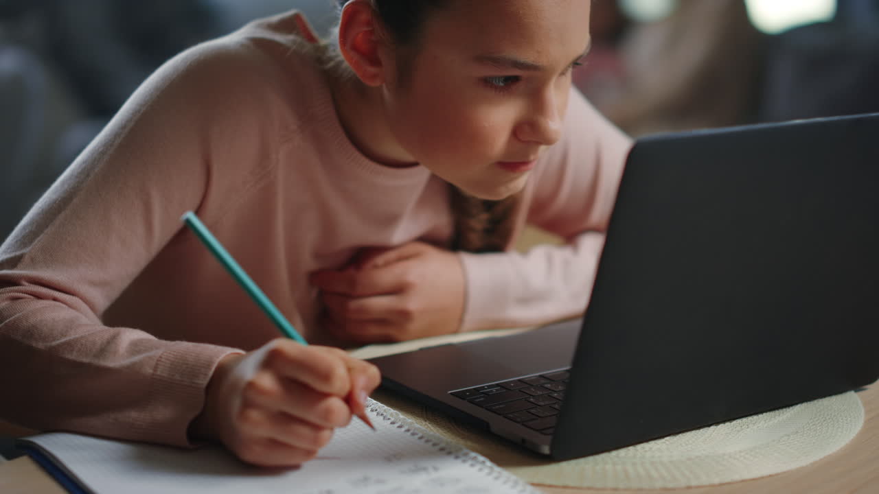 una adolescente estudiando en casa.