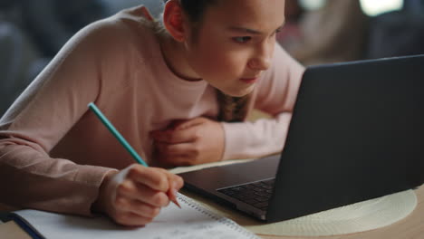 una adolescente estudiando en casa.