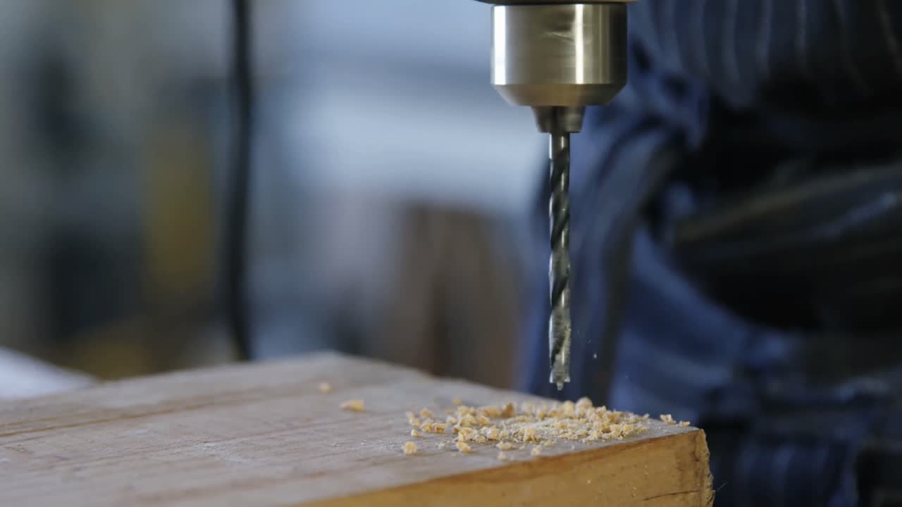 carpintero perforando tabla de madera con máquina en el taller 4k