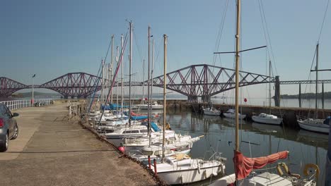puerto con el cuarto puente ferroviario en la distancia con aguas tranquilas y cielo despejado