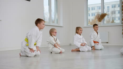 Kids-kneeling-on-the-floor-in-martial-arts-class