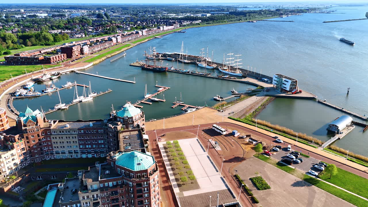 Port of beautiful Lelystad, the Netherlands with some boats and ships at the berths. Approaching the stunning ensemble of buildings at the waterfront of lake Markermeer.