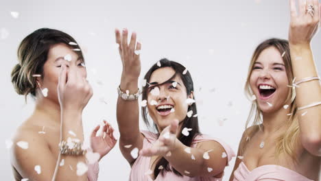 happy bridesmaids throwing confetti