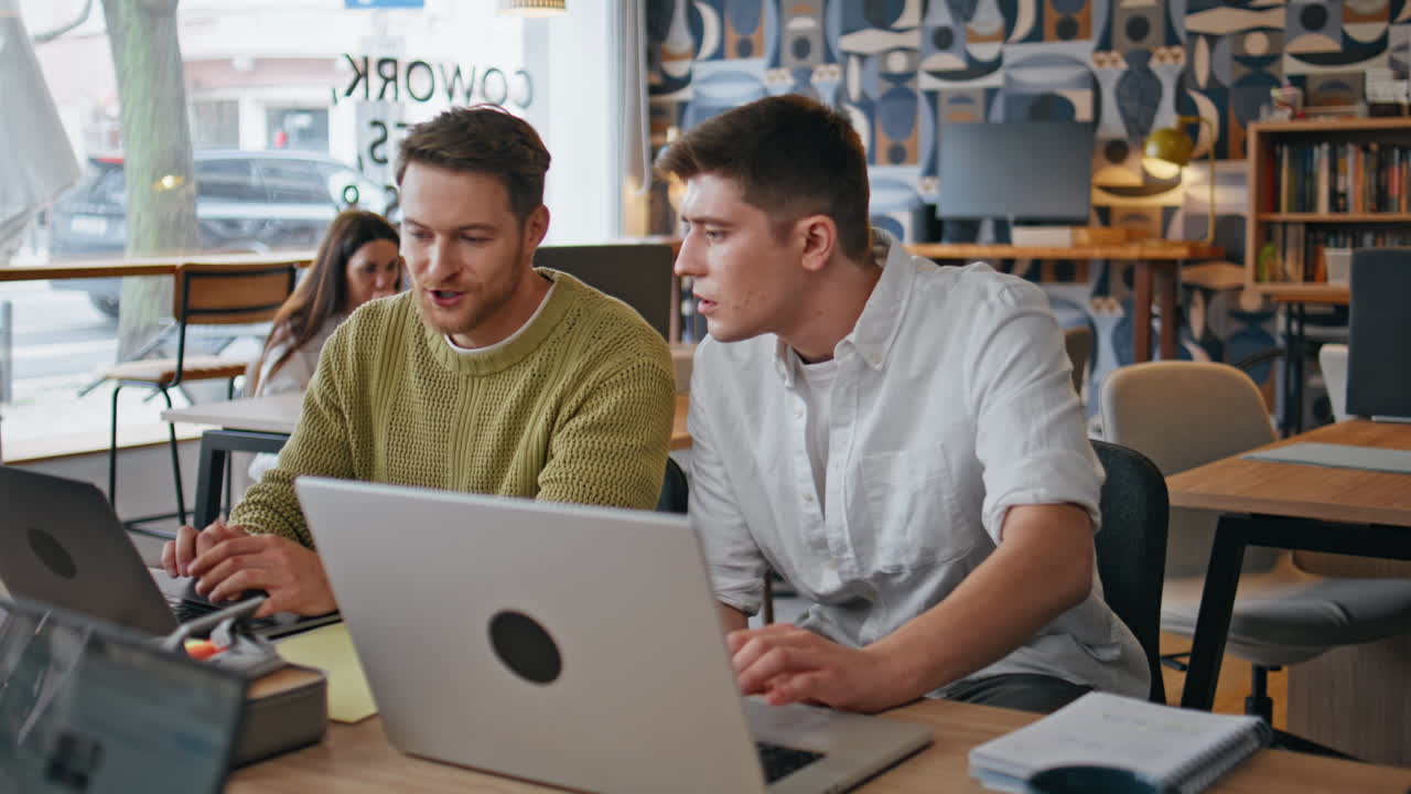 Two guys talking office closeup. Young designer speaking with man assistant work