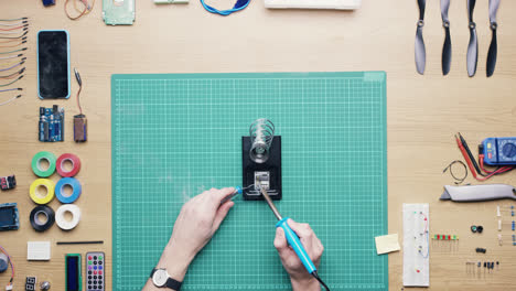 top view technician soldering circuit board working at desk from above - red epic dragon