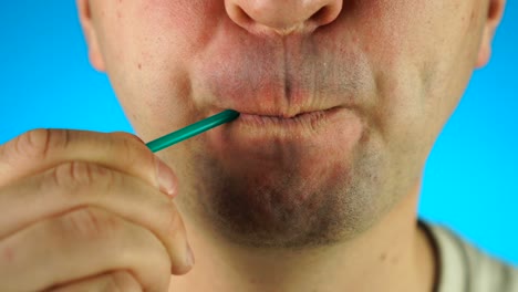 unrecognizable man with lollipop on blue background