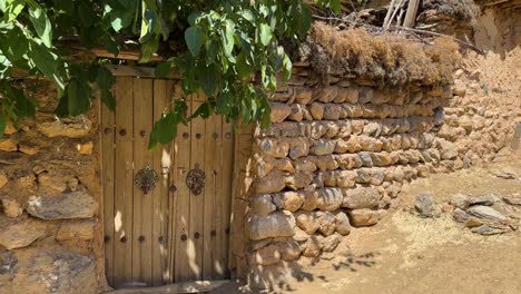 Wunderschöne-Malerische-Aufnahme-Von-Einem-Alten-Traditionellen-Haus,-Holztür,-Steinmauer,-Baumschatten-In-Ländlicher-Dorflandschaft-Im-Iran,-Esfahan,-Abgelegene-Outdoor-Abenteuerreise,-Um-Das-Leben-Der-Einheimischen-Zu-Besuchen,-Türklinke