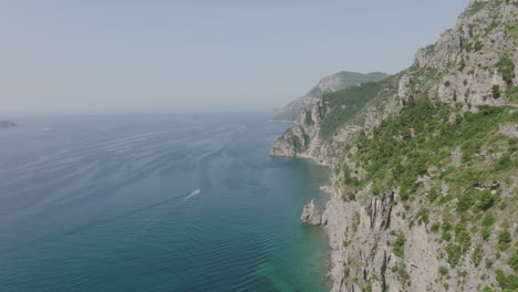 wide aerial footage on the amalfi coast showing a boat on the mediterranean sea