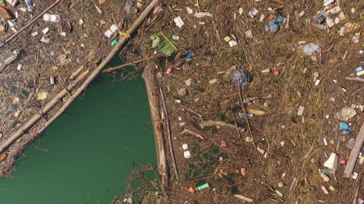 Aerial View of Plastic Waste and Debris Floating in Polluted River