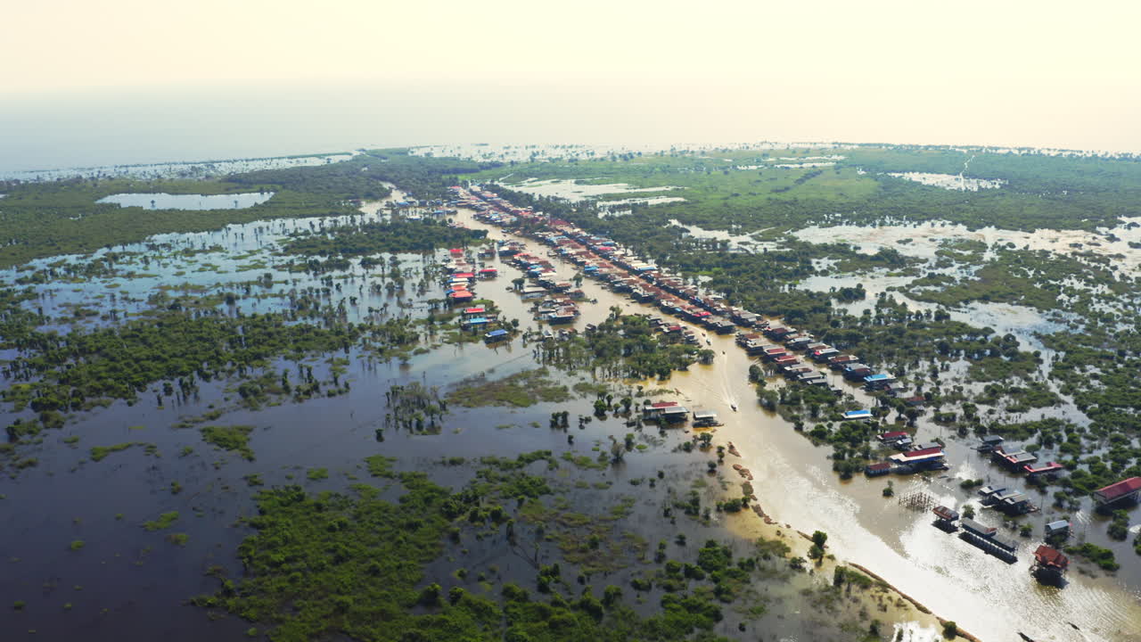 Sun reflecting off the flooded fishing village Kompong Phluk, Cambodia, panoramic aerial dolly