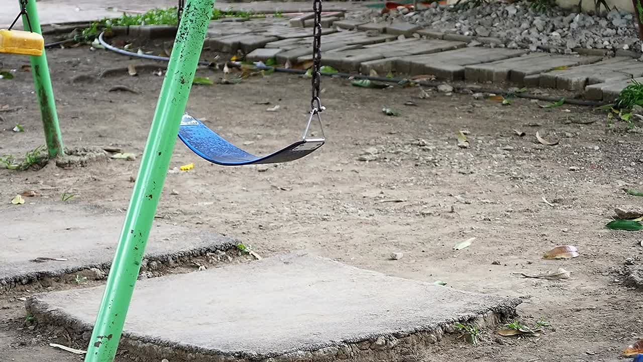 un conjunto de columpios para niños en una antigua instalación de patio de recreo en una subdivisión residencial suburbana en la ciudad de mandaue, filipinas