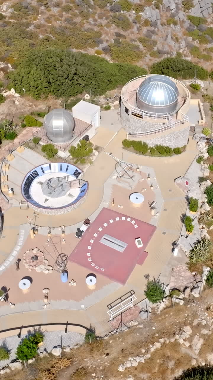 Vertical drone shot circling the Faliraki observatory, in sunny Rhodes, Greece