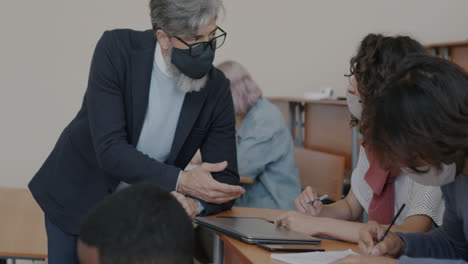 teacher assisting students in a classroom setting