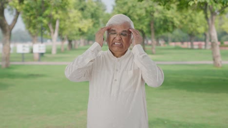 Sick-Indian-old-man-having-a-headache-in-park