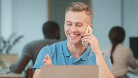 Joven-Hablando-Por-Teléfono-En-El-Lugar-De-Trabajo.-Retrato-De-Un-Chico-Rubio-Hablando-Informalmente