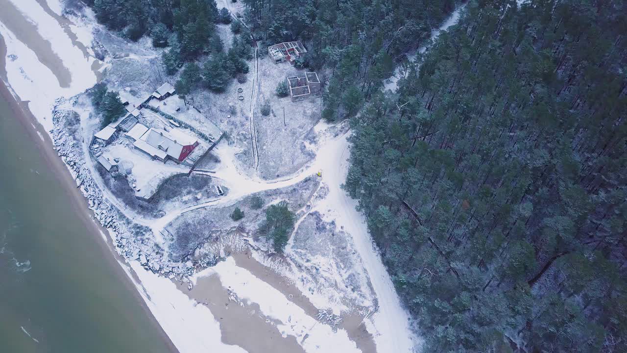 красивый вид с воздуха на побережье балтийского моря в пасмурный зимний день, пляж с белым песком, покрытым снегом, эрозия берегов, изменения климата, широкоугольный панорамный снимок с дрона, движущийся влево