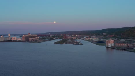 Aerial-view-large-scale-grain-storage-facilities-and-Taconite-piles-Duluth-Industrial-area-Rice's-point-at-sunset---drone-flying-shot-high-angle