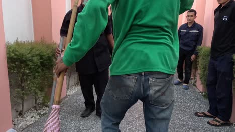 individual cleaning a walkway with a broom