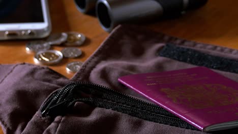 dropping passports and a wallet onto a desk prior to packing for travel close up