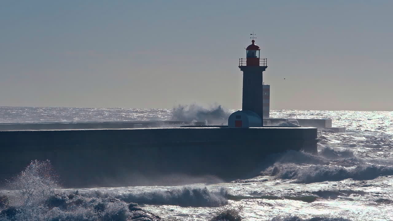 Portugal's coastal lighthouse apron paving withstands the relentless embrace of crashing waves&mdash;a dynamic spectacle, where nature and architecture converge in a symphony of strength