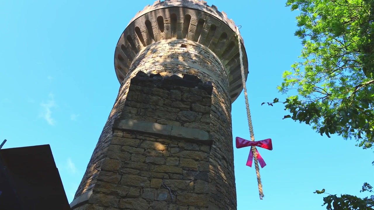 Figura animata di Raperonzolo che tira su la sua lunga treccia dalla Torre di Raperonzolo Emichsburg al Blühendes Barock a Ludwigsburg, Germania