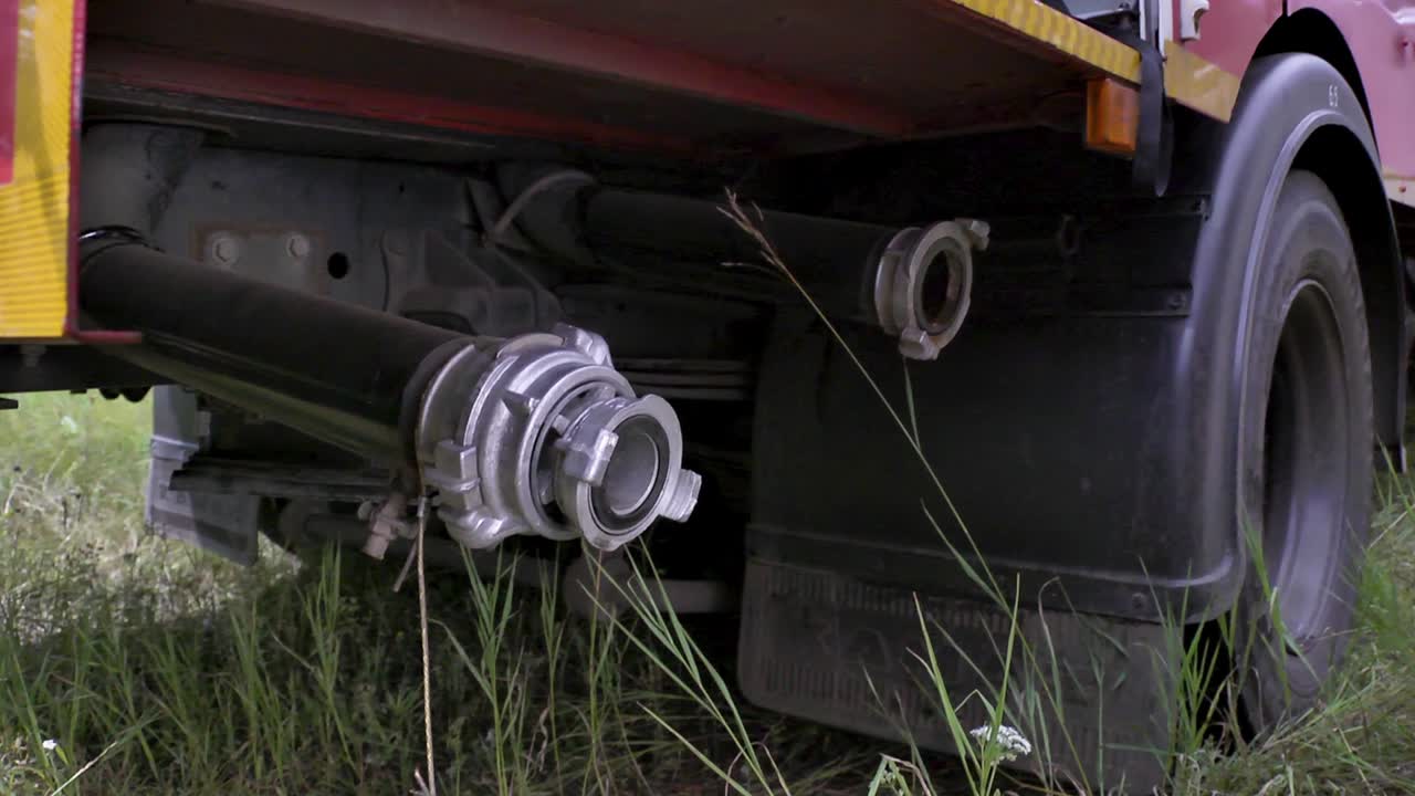 소방관 은 소방 호스 를 소방 차량 과 연결 하고 있다