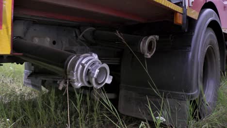 firefighter connecting fire hose to firetruck