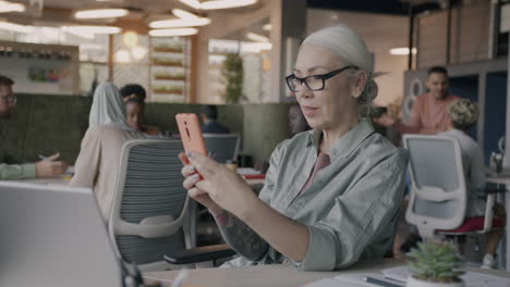 mujer de negocios usando teléfono inteligente en la oficina