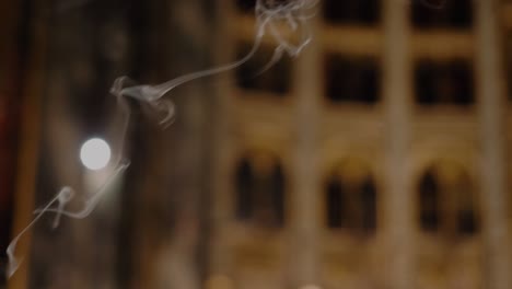 close up slow motion shot of candle smoke inside church